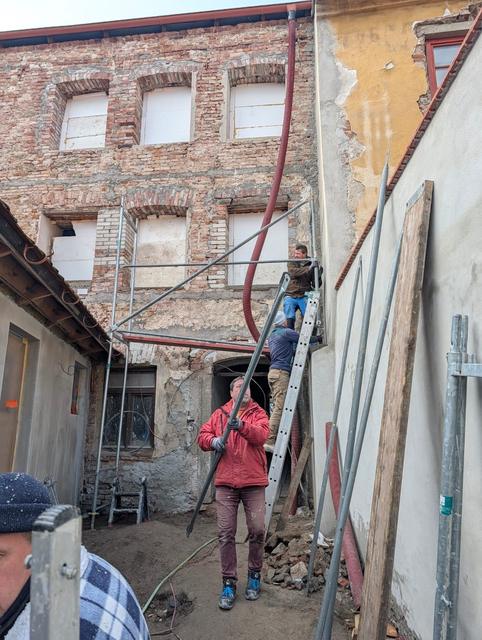 Strojní omítání dvorní fasády nad odhaleným cihelným zdivem