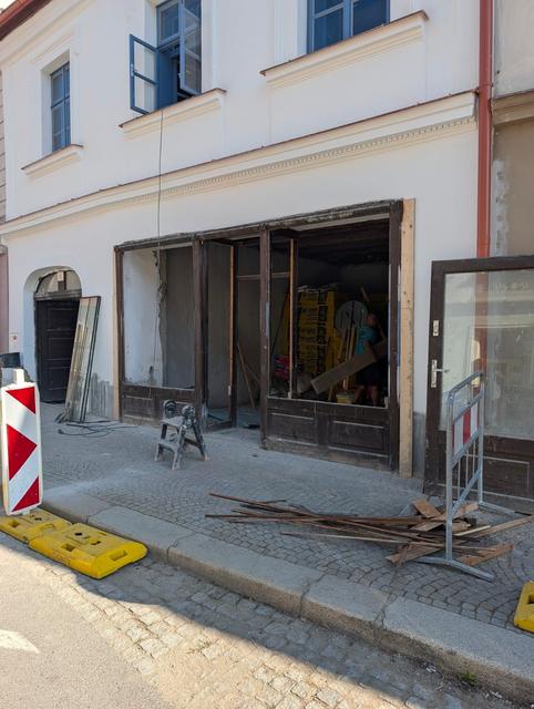 Pohled z ulice na dům během rekonstrukce výkladce